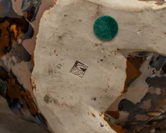 Closeup of one of the three Chinese porcelain large figures of foo dogs or temple lions, the largest one in a pale celadon green glaze with brown accents, one in a rich mottled brown and black glaze, and one in a warm brown and vivid green glaze