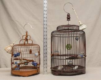 Two vintage Chinese bamboo song bird cages, with blue and white and enameled porcelain feed bowls; one birdcage with a finely carved dragon perch.