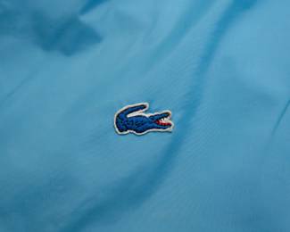 Closeup of vintage '80s baby blue Lacoste nylon taffeta waterproof trench coat