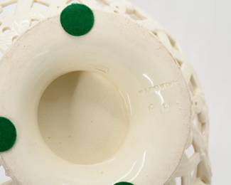 Closeup of the A late 19th century antique Wedgwood cream ware footed “orange bowl” and cover, beautifully crafted with symmetrical pierced lattice work, garland and foliate scrolls with applied twisted rope handles and a flower finial. 10” high x 9” wide. Impressed Wedgwood stamp beneath the circular foot. 