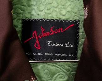 Closeup of a beautiful vintage embroidered silk coat by Johnson Tailors Ltd in Kong Kong, rich coffee brown silk embroidered with multicolor flowers, and spring green silk lining