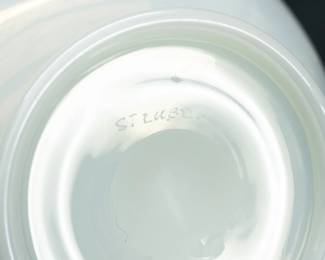 Closeup of the early 20th century (circa 1920-1933) American hand blown Steuben art glass vase made from luminous iridized Ivrene glass in shape #7565, a documented design by Steuben Glass Works co-founder Frederick Carder. The bulbous form sits on a narrow dome base, the neck with flaring optic ribs and graceful scalloped rim that has a narrow applied edge of light blue glass. Marked "Steuben" in script on underside of base. 9 inches wide x 10 inches high. 