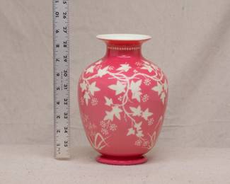 A beautiful cameo carved art glass vase, cased uranium glass of warm rosy pink over white and carved with trailing ivy vines