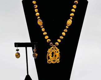 The warmth and silky richness of tigers eye natural quartz - shown here in a striking Chinese carved lion pendant and bead necklace , a pair of dangle bead earrings and a chunky tigers eye beaded bracelet