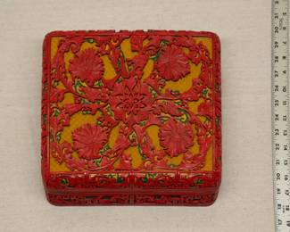 A large vintage Chinese cinnabar lacquerware lidded box, skillfully carved with peony flowers motif on a golden geometric ground, original maker's label to base.