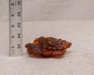 A carved amber piece in the form of a cicada resting on a cluster of grapes - a rich deep beautiful color!