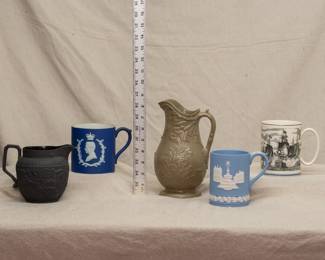 Vintage Wedgwood pitchers and mugs including a drabware pitcher, a jasper dip mug commemorating King Edward VIII coronation, a Wedgwood "Battle of Trafalgar" Lord Nelson tankard mug, and a Wedgwood black basalt 'Four Home Nations' creamer embossed the four home nations Wales (harp), Ireland (shamrock), England (rose) and Scotland (thistle) and arabesque relief