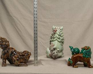 Another view of the three Chinese porcelain large figures of foo dogs or temple lions, the largest one in a pale celadon green glaze with brown accents, one in a rich mottled brown and black glaze, and one in a warm brown and vivid green glaze