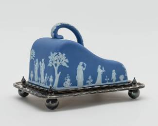 Another view of the early 20th Century Wedgwood cheese dome of blue Jasperware with its original silverplated tray. The blue dome with white classical figures including Cupid and Diana with stag in bas-relief, the applied handle with white acanthus leaves. Marked to the inside with WEDGWOOD and MADE IN ENGLAND. The silverplated tray is original to the cheese dome set, and is raised on ball feet; hallmarks to the underside are from H. Fisher & C, silversmiths in Sheffield, England.
