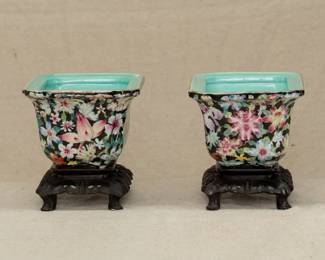 Another view of the pair of Chinese porcelain jardinières, rectangular with millefleur decoration in polychrome enamels, each stamped "China" and with carved wooden stands