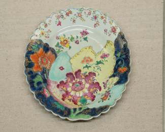 A Chinese export porcelain "Tobacco Leaf" plate richly enameled with the classic pattern in vivid famille rose colors heightened in gilt, with scalloped rim; Qianlong period.