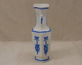 Another view of the antique c. 1820 Wedgwood white jasper two-handled vase with applied blue sprig classical Greek figures and both arts and military symbols decoration. Stamped Wedgwood to the base – each letter individually stamped in —and a blue sprig oval embossed "pad mark" showing the numerals 979 for the shape number.