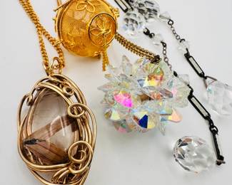 Closeup of some of the pendant necklace costume jewelry including guillochet wire wrapped natural stone, AB crystals  