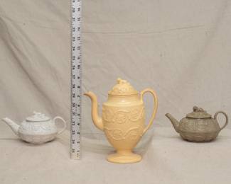 Two early 19th Century Wedgwood salt-glazed stoneware teapots with King Charles spaniel finials (see same in the Cleveland Museum of Art) circa 1830, with a spectacular 19th Century Wedgwood caneware coffee pot or chocolate pot with scrolling foliate motif with floral blossoms, lid with a surmounting dog form finial.