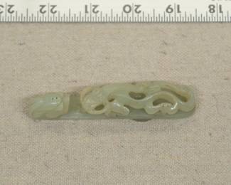 A Chinese carved jade "dragon" belt hook, carved with a scroll form chilong facing a dragon head terminal