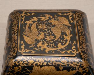 Another view of the fine Chinese export black lacquer carved box with gilt painted detailing of peony scrolls and a central panel of flying phoenix birds; the interior of the box painted oxblood red  