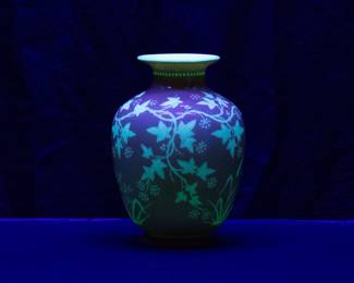 Seen under blacklight: A beautiful cameo carved art glass vase, cased uranium glass of warm rosy pink over white and carved with trailing ivy vines