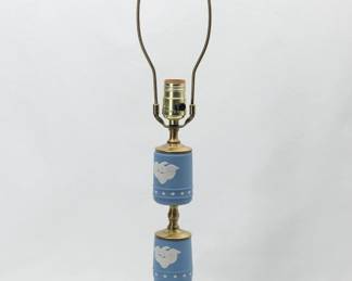 A beautifully crafted Wedgwood blue Jasperware table lamp from the American bicentennial series. Made in three tiers, the base with a circlet of intricately modeled white grapevines in bas-relief, above are two barrel shaped pieces with white eagles, wings outstretched, perched on a shield above a band of stars. Surmounted with a circular pierced decoration finial. 26.5” H x 7” W. With brass hardware.