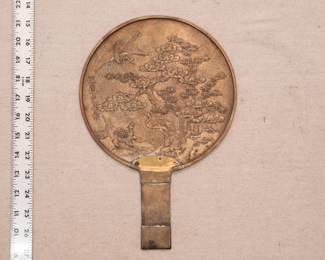  Japanese vintage hand mirror of patinated bronze, Meiji period (1868-1912), the detailed non-reflecting part is decorated in relief with an aquatic landscape in which are a crane, a turtle and a pine tree, all auspicious symbols of longevity.
