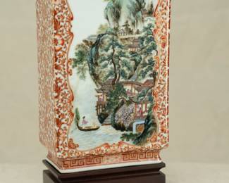 Closeup of the Chinese rectangular vase dating from the 1950s with wooden stand. Vase features a coral red lotus and flower tracery ground and 2 famille rose enameled landscape scenes on the front and back. The bottom of the vase has a 4-character mark.