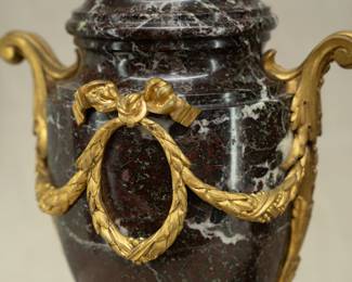 Closeup of the pair of neoclassical style ormolu or gilt bronze and marble urn form lamps
