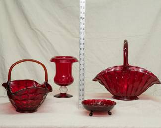 Vintage deep red glass works of art including a Pairpoint ruby red rolled edge urn form footed vase, an Anchor Hocking royal ruby footed candy or relish dish, a Tiara Glass red glass basket, and a large glorious cranberry red hand blown glass centerpiece basket 