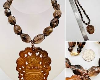 A Chinese beaded necklace with smokey quartz and a natural stone carved pendant depicting a potted plant in bloom