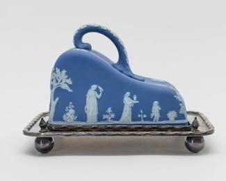 An early 20th Century Wedgwood cheese dome of blue Jasperware with its original silverplated tray. The blue dome with white classical figures including Cupid and Diana with stag in bas-relief, the applied handle with white acanthus leaves. Marked to the inside with WEDGWOOD and MADE IN ENGLAND. The silverplated tray is original to the cheese dome set, and is raised on ball feet; hallmarks to the underside are from H. Fisher & C, silversmiths in Sheffield, England.