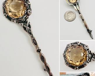 A 19th century Scottish sterling silver kilt pin mounted with a circular citrine in cut-away setting, hallmarks include a thistle stamp for being crafted by artisans in Scotland, and a silversmith stamp of "RA"