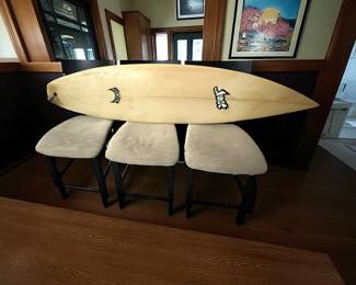 Three barstool height, stools, one surfboard