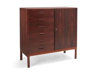 241
A Danish Modern rosewood highboy chest
Mid-20th century
Marked verso: Made in Denmark / [unknown cipher] / 104
The rosewood veneer chest, one side with six drawers with inset pulls, the other with a locking hinged cabinet door revealing six open sliding drawers
46.5" H x 45.5" W x 18" D
Estimate: $500 - $700