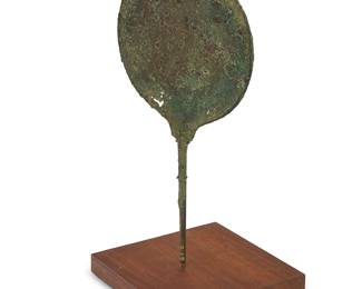 327
An Etruscan bronze hand mirror
800-300 BCE or later
With obscured figural representation within a geometric border, mounted on a wood and metal stand
Mirror: 11.75" H x 6.125" W x 0.375" D; Overall: 13" H x 6" W x 6" D
Estimate: $800 - $1,200