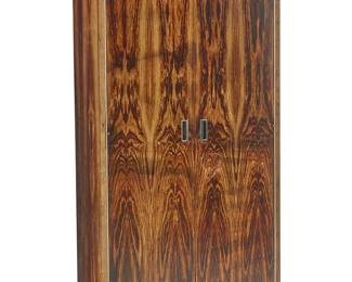 275
Robert Baron (1925-2014)
A rosewood wardrobe for Glenn of California, late 20th century
With manufacturer's label to interior of top drawer: Glenn / Carson / California; further marked with manufacturer's metal tag aside mirror
The rosewood veneer wardrobe with two cabinet doors, each with metal inset pulls, the left mounted with a mirror, opening to reveal a retractable hanging rack above side pegs for shelves not extant, and four drawers
76.25" H 36" W x 20" D
Estimate: $800 - $1,200