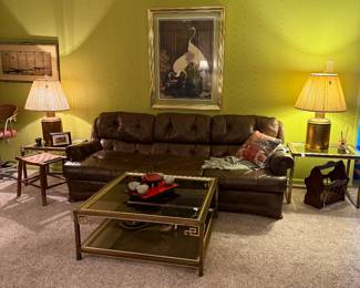 Faux leather couch, (2) brass lamps, glass and metal matching coffee table and nesting table