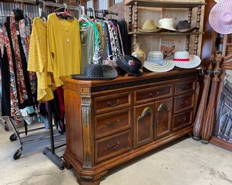 Nice wood dresser, lots of women's clothes, sun hats, cowboy/cowgirl western looking hats, fedora looking black hat, 