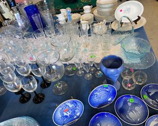 So much glassware! Wine glasses of different sizes, shapes, stem color, etc! Dark blue decorative plates with animals on them. Light blue glass bowl and so much more!