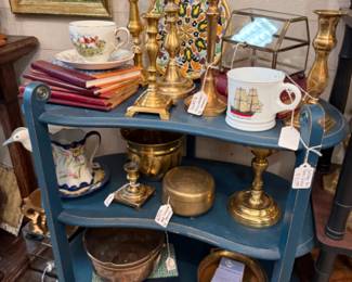 lots of brass scattered throughout the store, mug, books, copper bowl