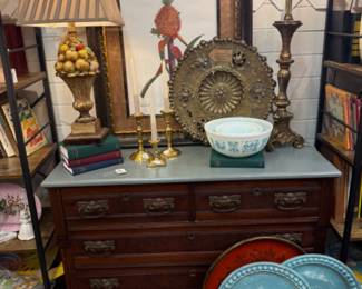 Vintage dresser with original beautiful handles with painted top. This would be a beautiful piece to decorate and use in a living room for storage and decorating. Framed pineapple print, decorative Italian tray, brass lamp, Amish butter print 3 bowl set, vintage books and a fruit lamp
