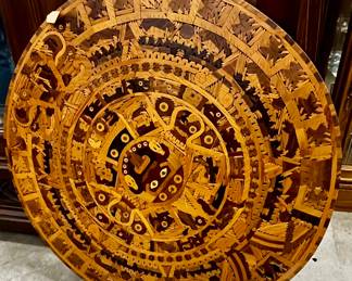 one of two large Native American wood carving depicting a calendar I'm pretty sure.  They could hang on wall or used as a table top. Very heavy and nice
