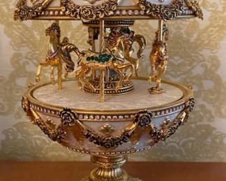 Carousel scene inside with miniature gilt horses that revolve.