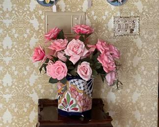 Great decor, a variety of floral decorative plates along with Carved Accent table with floral arrangement in Talavera-style pot