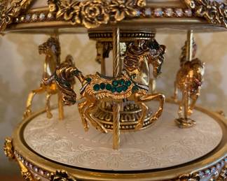 Egg-Shaped form with ornate gilt detailing, plays music while the carousel rotates, Maker: House of Faberge