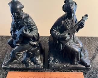 L24 - $60. Austin Reproductions Japanese Geisha and Man Playing Shamise Figures/Bookends  - Signed "Lioo" Measures 6.5" x 11" tall. 