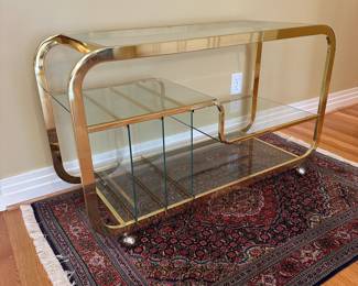 L3 - $750. Milo Baughman Brass and Glass 3 Tier Bar Cart. Measures 46.5" x 18" x 28" tall. The bottom right piece of glass has a chip we didn't notice until we were looking at it for issues. The glass could be replaced but if there is something near it you can't see it. 