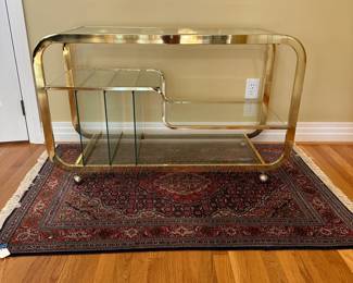 L3 - $750. Milo Baughman Brass and Glass 3 Tier Bar Cart. Measures 46.5" x 18" x 28" tall. The bottom right piece of glass has a chip we didn't notice until we were looking at it for issues. The glass could be replaced but if there is something near it you can't see it. 