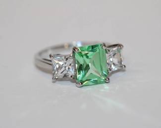 10kt white gold Green and White Spinel Ring that features a central prong set approx 1.5ct emerald cut green spinel with an additional .75ct clear spinel on each side total for all stones is approx 3ctw, size 7.25, 3.3 grams total weight