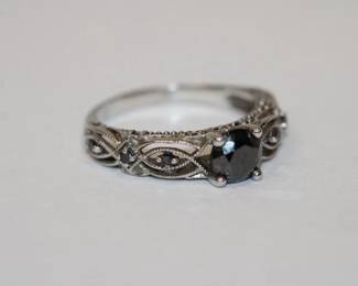 10kt white gold Black Diamond Ring that features a round prong set black diamond (tested on presidium gem tester) ad an additional 6 round diamonds 3 on each side, total weight for all 7 diamonds is approx .50ctw, it is marked 10k and with A D, size 7, 2