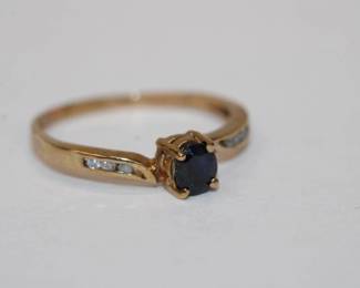 10kt yellow gold Sapphire and Diamond Ring with a prong set oval sapphire that weighs approx .25ct and is accented by 6 chanel set round diamonds, three on each side, size 7.5, 1.5 grams total weight