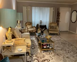 French Provincial couch and chair, end tables, rug, gold entry divider, black and gold beveled mirror.