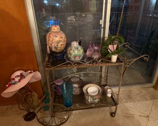 Gold tea cart. Asian pottery. Glassware. Pink flower hat.